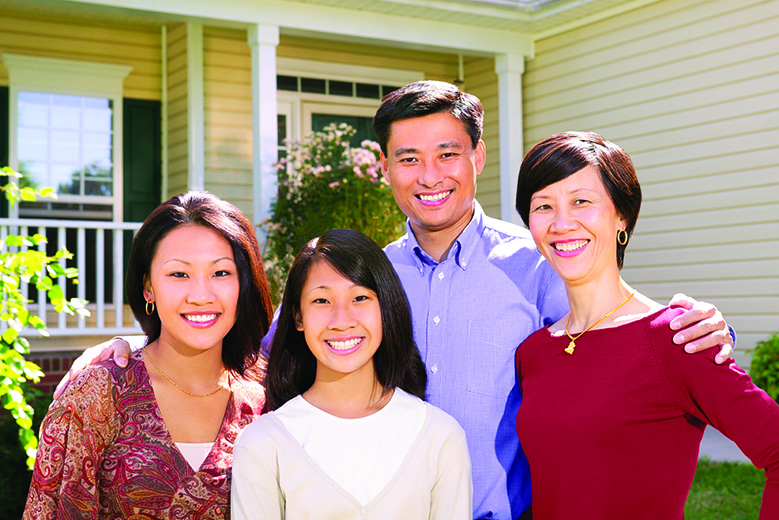 A Happy Family Standing in Front of a House