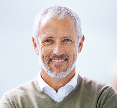 An older man smiling at the camera